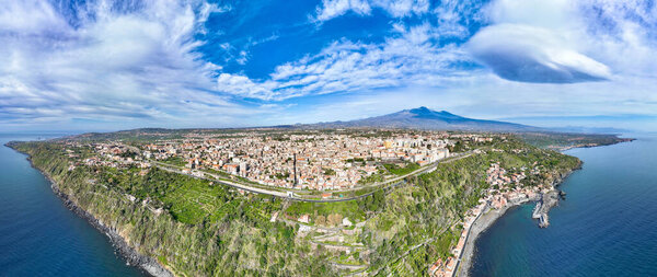 Panoramica aerea dall'alto sulla Timpa di Acireale e Santa Maria la Scala con vulcano Etna con cielo e mare blu