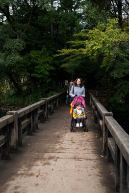 TOKYO, JAPONYA - 28 Ekim 2024 - Tokyo 'da sonbahar mevsimi boyunca Inokashira Parkı ve Benzaiten Tapınağı' nda anne ve bebek arabasının yatay fotoğrafı