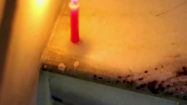 Işıklı mum düz açıyla karanlık ortamda yanıp sönüyor.