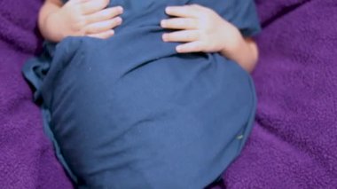 Sevimli yeni doğmuş bebek anne avucunun içinde uyuyor. Üst açıdan çekilmiş.