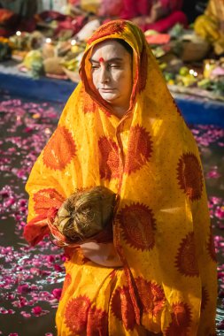 Kadınlar nehirde durup Chhas festivalinde güneş tanrısı için dua ederler.