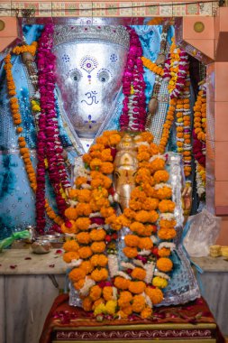 Hindistan 'da Ganesh Tapınağı Ranada Jodhpur Rajasthan' da çekilen düz açılı çekimde çiçeklere tapan Hindu tanrı Ganesha idolü..