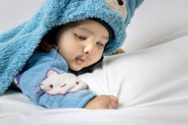 Beyaz arka planlı, sevimli bir yüz ifadesi takınan küçük çocuk.