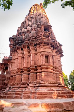 Mandore Garden Jodhpur Rajasthan Hindistan 'da çekilen eşsiz bir açı ile parlak gökyüzü ile antik Hindu tapınağı mimarisi.