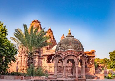Mandore Garden Jodhpur Rajasthan Hindistan 'da çekilen eşsiz bir açı ile parlak mavi gökyüzü ile antik Hindu tapınağı mimarisi.