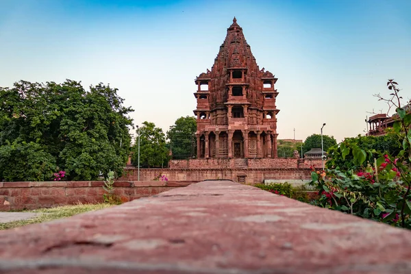 Mandore Garden Jodhpur Rajasthan Hindistan 'da çekilen eşsiz bir açı ile parlak gökyüzü ile antik Hindu tapınağı mimarisi.