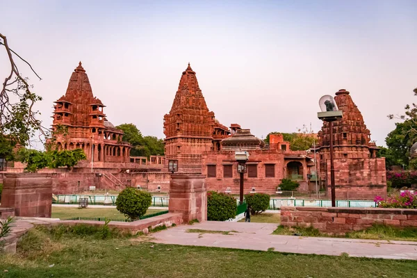 Mandore Garden Jodhpur Rajasthan Hindistan 'da çekilen eşsiz bir açı ile parlak gökyüzü ile antik Hindu tapınağı mimarisi.