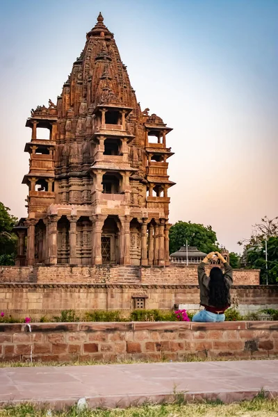 ancient hindu temple architecture with girl witnessing it at evening from flat angle at day