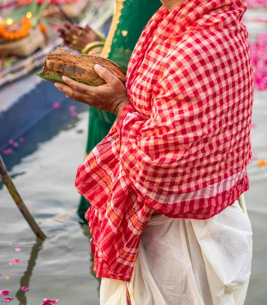 man devotee with religious offerings for sun god during Chhath festival from flat angle