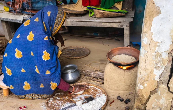 Stock image women making rice bread in traditional soil vessels at wood fire from different angle at village