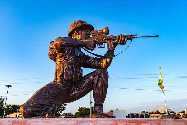 stock image isolated soldier statue with gun from different angle with bright sky at evening shot is taken at jaisalmer war memorial rajasthan india on Jan 25 2023.