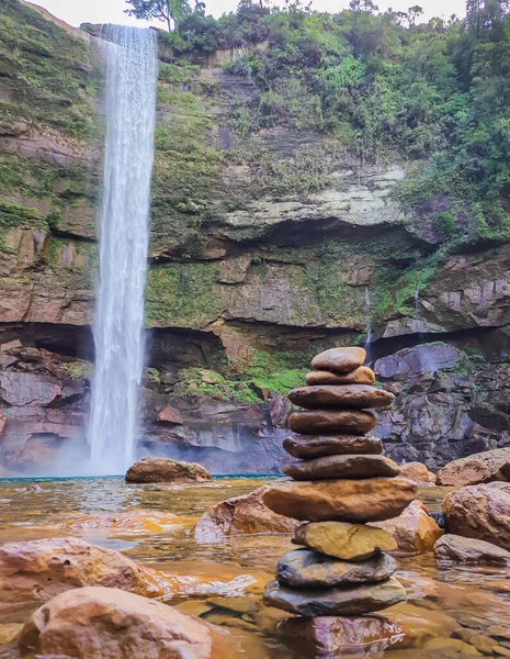 waterfall falling from mountain with pile of stones at day from different angle shot is taken at meghalaya.