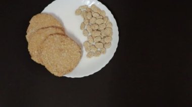 Beyaz tabakta siyah arkaplanlı Hint geleneksel tatlı tilkut