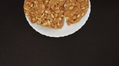 Beyaz tabakta siyah arkaplanlı Hint geleneksel tatlı tilkut