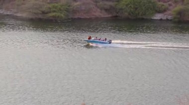Hız teknesi gün içinde göle doğru hızla ilerliyor. Kaylana Gölü Jodhpur Rajasthan Hindistan 'da çekiliyor..