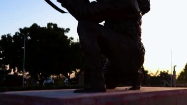 İzole edilmiş asker, akşamları farklı açılardan silahlı ve çarpıcı gökyüzüyle yanan heykel yakıyor.