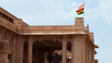 Krallık bayrağı sarayın girişinde gün içinde kırmızı taştan yapılmış düz açıyla çekilen video, umaid Bhawan Palace Jodhpur lndia 'da çekilmiştir..