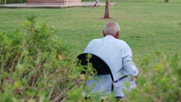 Stary Człowiek Samotnie Siedzi Żelaznym Krześle Parku Tyłu Wieczór — Wideo stockowe