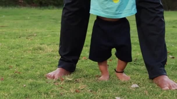 Vader Helpen Zoon Voor Lopen Groen Gras Tuin Avonds — Stockvideo