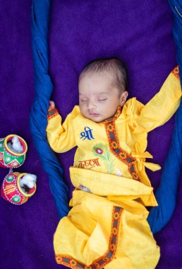 Krishna 'da yeni doğmuş bir erkek bebek. Farklı açılardan farklı bir şekilde sallanan aksesuarlarla süslenmiş.