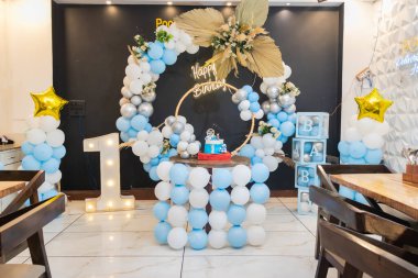 Farklı açılardan beyaz ve mavi balonlu bir doğum günü süslemesi