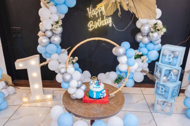 Farklı açılardan beyaz ve mavi balonlu bir doğum günü süslemesi