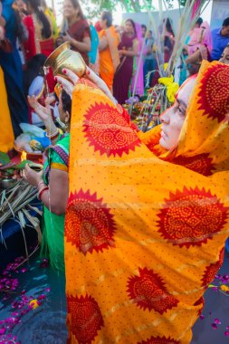 Kadınlar nehirde durup Chhas festivalinde güneş tanrısı için dua ederler.