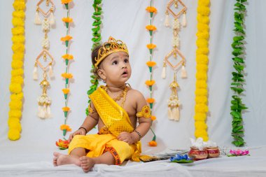 Hindistan 'da Janmashtami kutlamalarında Hindu tanrısı Krishna gibi giyinmiş sevimli bir bebek.