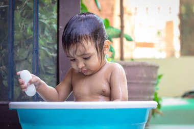 Yavru dışarıda küvette banyo yapmaktan zevk alıyor.