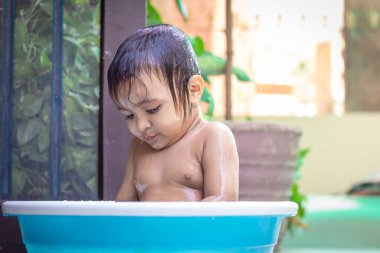 Yavru dışarıda küvette banyo yapmaktan zevk alıyor.