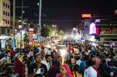 Festivalde akşam saatlerinde şehir caddesinde alışveriş yapan kalabalık, Sardar pazarından düz açıdan çekilen görüntü GantaGhar Jodhpur Rajasthan Hindistan 'da 06 Kasım 2023' te çekilmiştir..