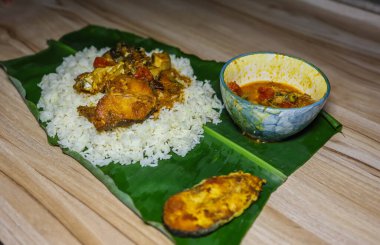 Akşam yemeğinde muz yaprağında servis edilen taze ve sıcak balık ve pilav.