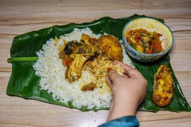 Akşam yemeğinde muz yaprağında servis edilen taze ve sıcak balık ve pilav.