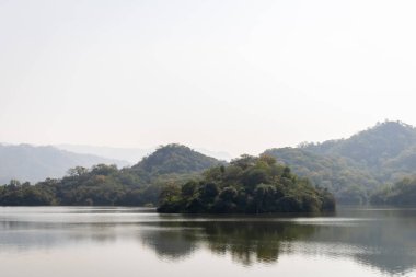 Puslu dağ manzarası, gün içinde düz açıyla el değmemiş göl.