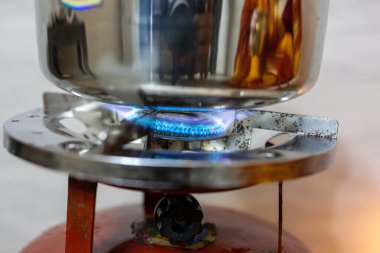 Bakır Yakıcı Gaz Ocağı 'nda yemek yapmak. Gün ışığında evde.