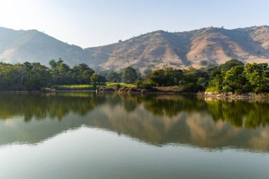 İzole bir dağ sırası. Sabah düz açıyla el değmemiş göl yansıması var.
