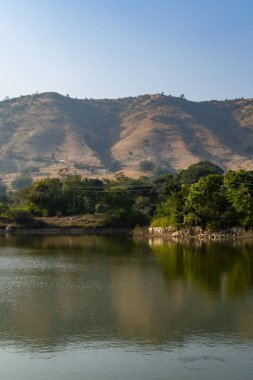 İzole bir dağ sırası. Sabah düz açıyla el değmemiş göl yansıması var.