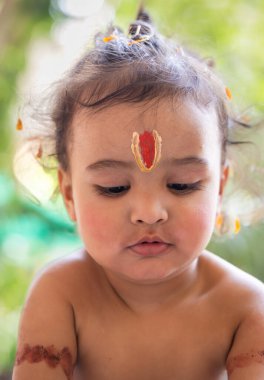 Kafasında kutsal dini semboller olan sevimli Hintli çocuk dışarıda, geçmişi bulanık.
