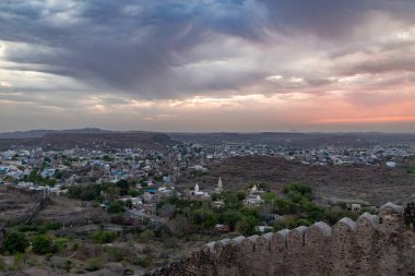 Şehir manzarası, turuncu gökyüzü ve antik kale duvarı ile mehrangarh kalesi Jodhpur rajasthan Hindistan 'da çekilir. üstte