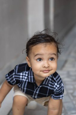 Siyah tişörtlü şirin bir çocuk. Farklı açılardan dışarı ateş ediyor.