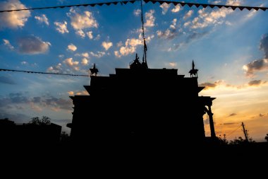 Akşam vakti dramatik günbatımı görüntüsü ve sanatsal Hindu tapınağı benzersiz bir bakış açısıyla.
