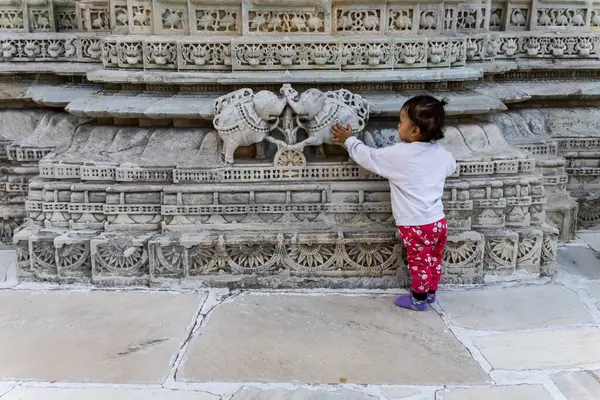 stock image cute kid touching ancient temple wall exterior unique art from different angle