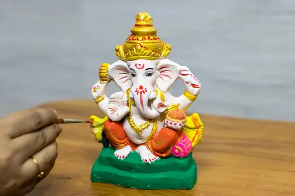 stock image devotee coloring the hindu god ganpati idol on the occasion of ganesh chaturthi