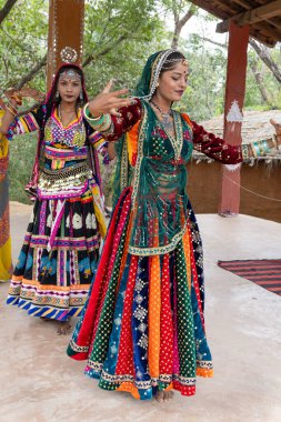 Genç Hintli kızlar geleneksel halk dansını Rajasthani kıyafetleriyle farklı açılardan yapıyorlar.