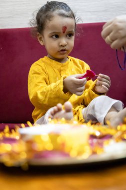 Hindu raksha Bandhan festivali vesilesiyle kapalı mekanda sevimli çocuk ifadesi.