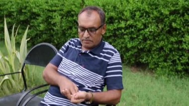 Tütün yakını kullanan bir adam akşamleyin düz açıyla parka ateş ediyor.