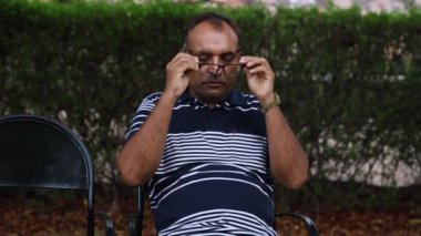 İzole edilmiş yaşlı bir adam akşamları düz açıyla parkta göz yorgunluğu çekiyor.