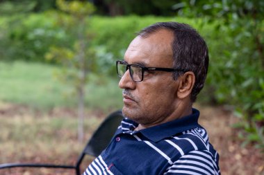 Yapayalnız bir adamın kafası düz bir açıdan akşam parka yakın çekim yapar.