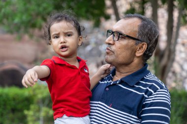 Büyükbaba, Alacakaranlık 'taki açık hava parkında sinirli torunu rahatlatıyor.