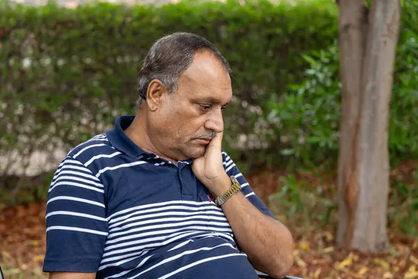 stock image isolated alone man in depression sitting at outdoor park at evening from flat angle